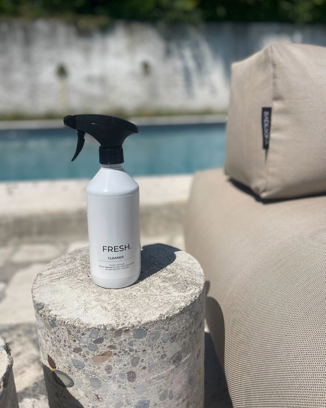 Reinigungsspray steht neben einem Poolsofa. $ Reinigungsspray